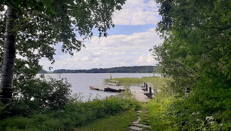 Kesäinen maisema jossa ranta ja laituri