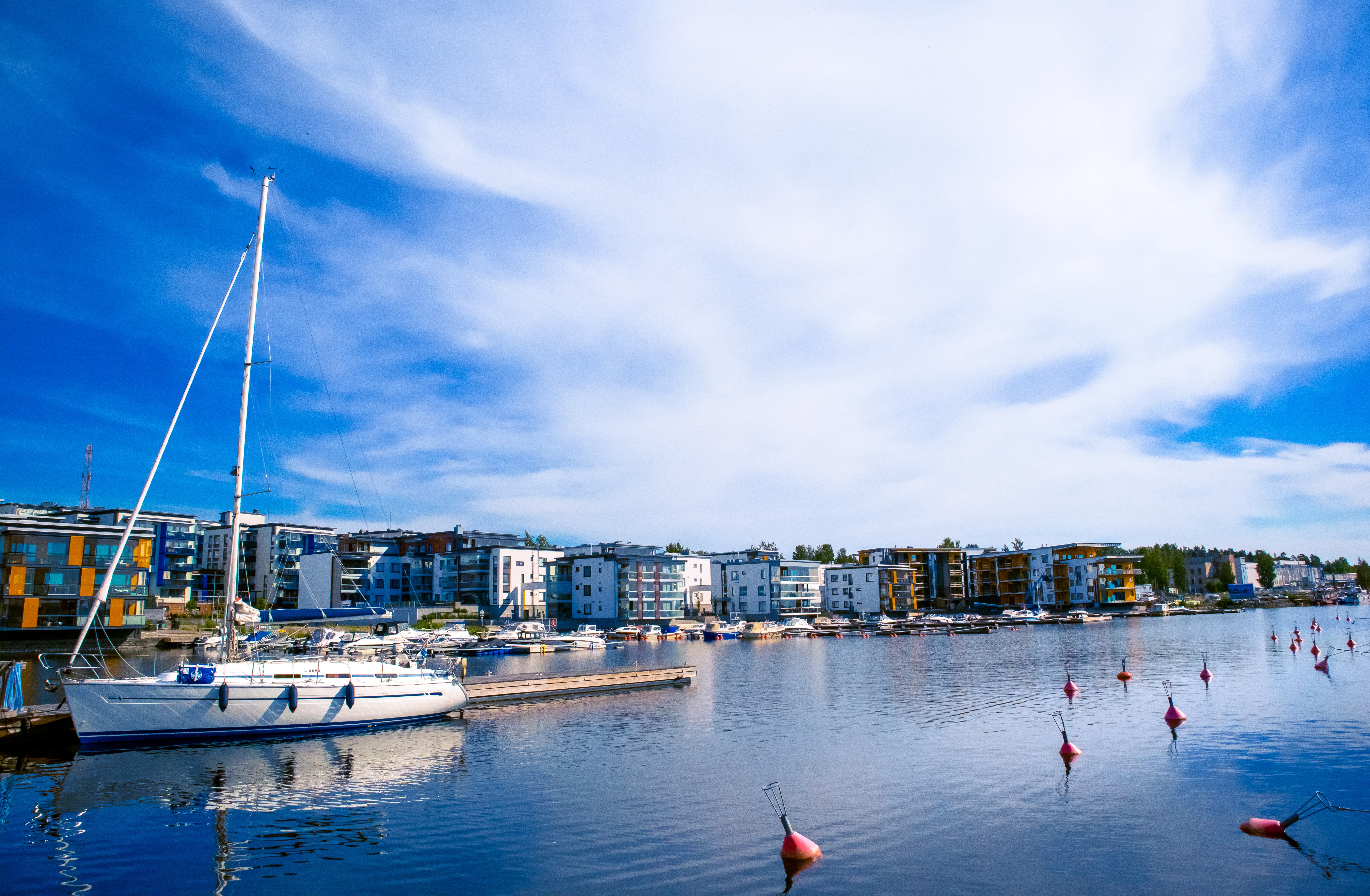 Järvimaisema kesällä, rannalla veneitä ja kerrostaloja