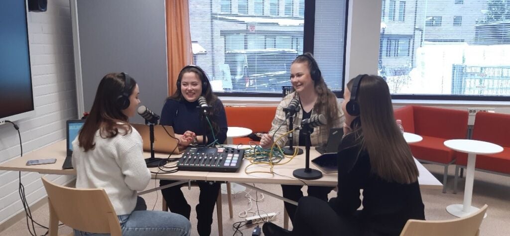 Students sitting around a table with recording equipment