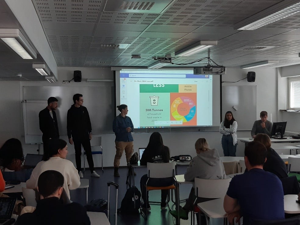 Classroom, three people standing in front of the room