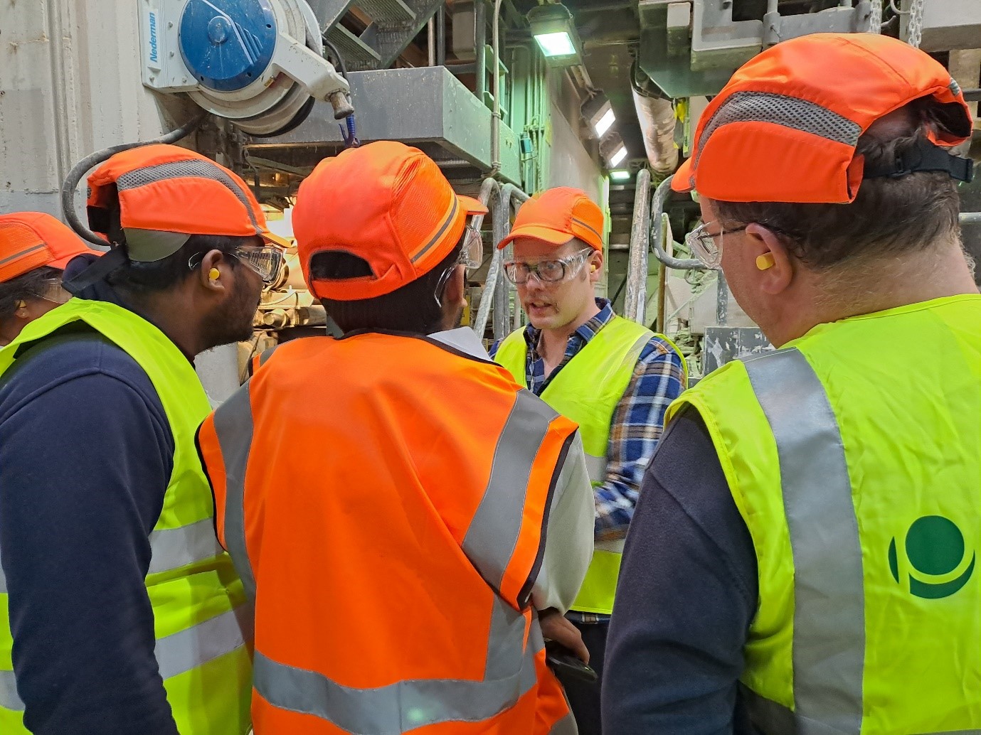 A group of men wearing safety vests and hats